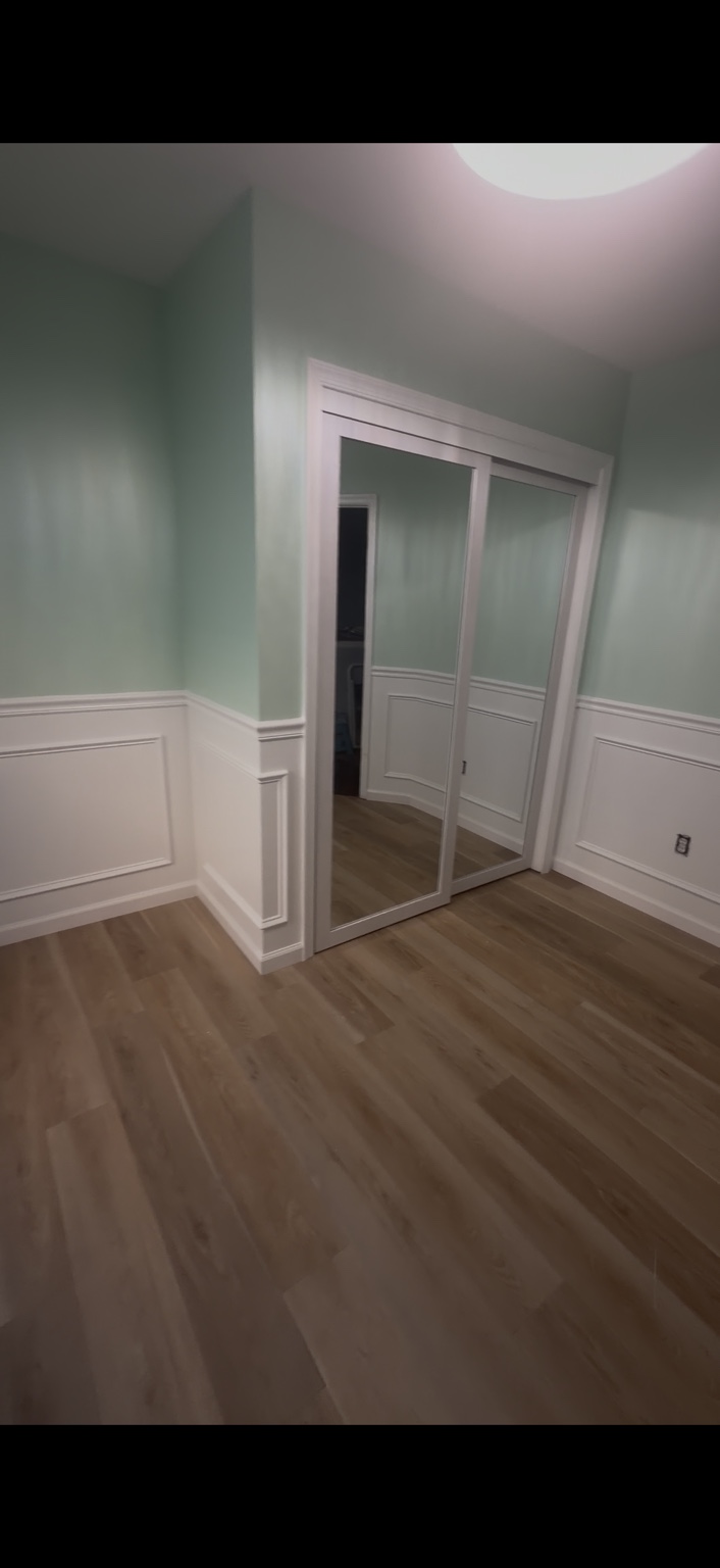 White wainscoting, chair rail, baseboards and closet door casing against pale green walls